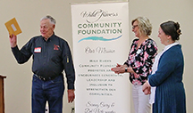man and woman standing in front of a Wild Rivers Community Foundation poster
