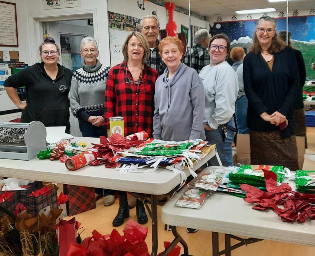 A group of volunteers poses with holiday gifts.