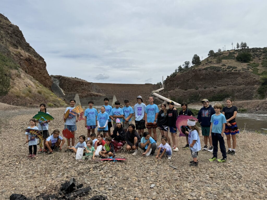 Group of 27 students stand outside in front of Klamath River and dam