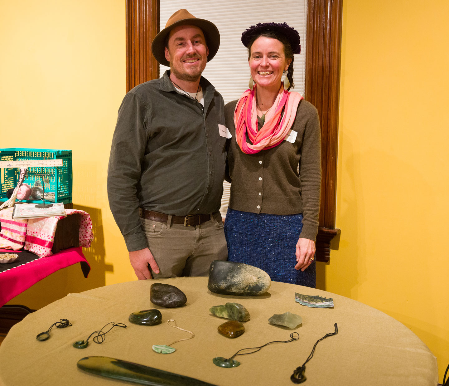 Man and woman post at table with hand-made jade jewelery during awards ceremony.