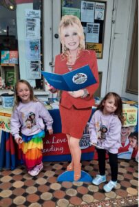 09_DAF_DollyParton Two young girls pose with a cardboard cut-out of Dolly Parton.